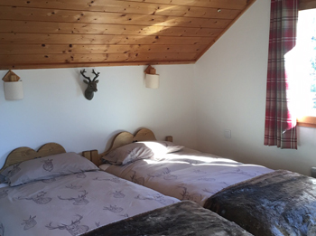 Image of bedroom with two beds and wooden ceiling